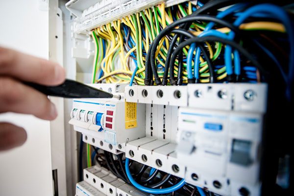 A professional electrician working on a residential electrical system.
